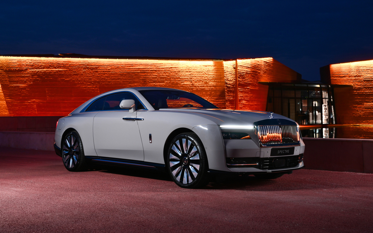 Дорогой автомобиль Rolls-Royce Spectre у здания