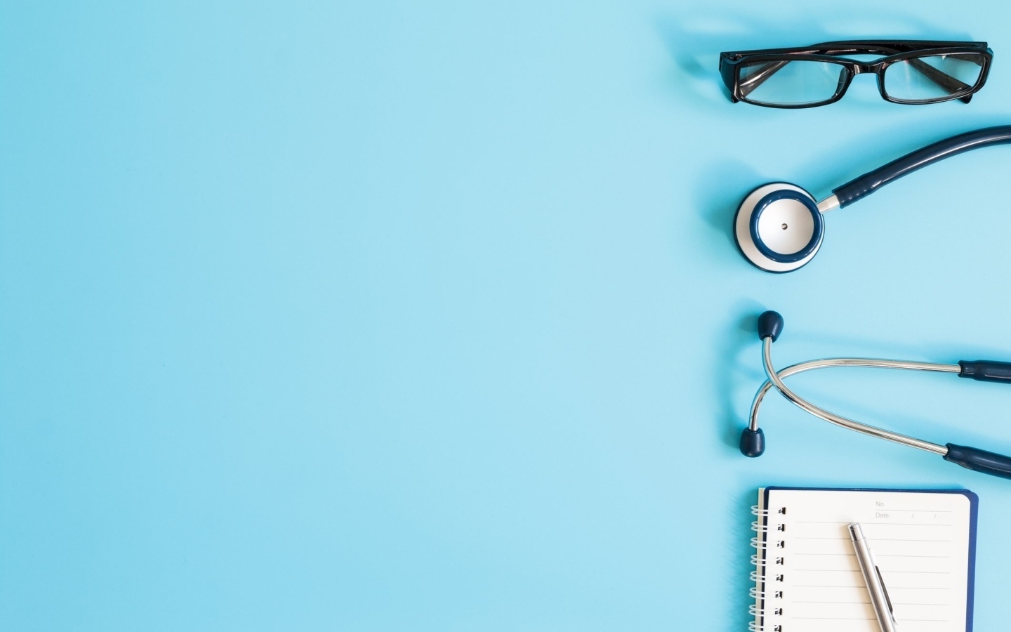 Стетоскоп, очки и блокнот на голубом фоне