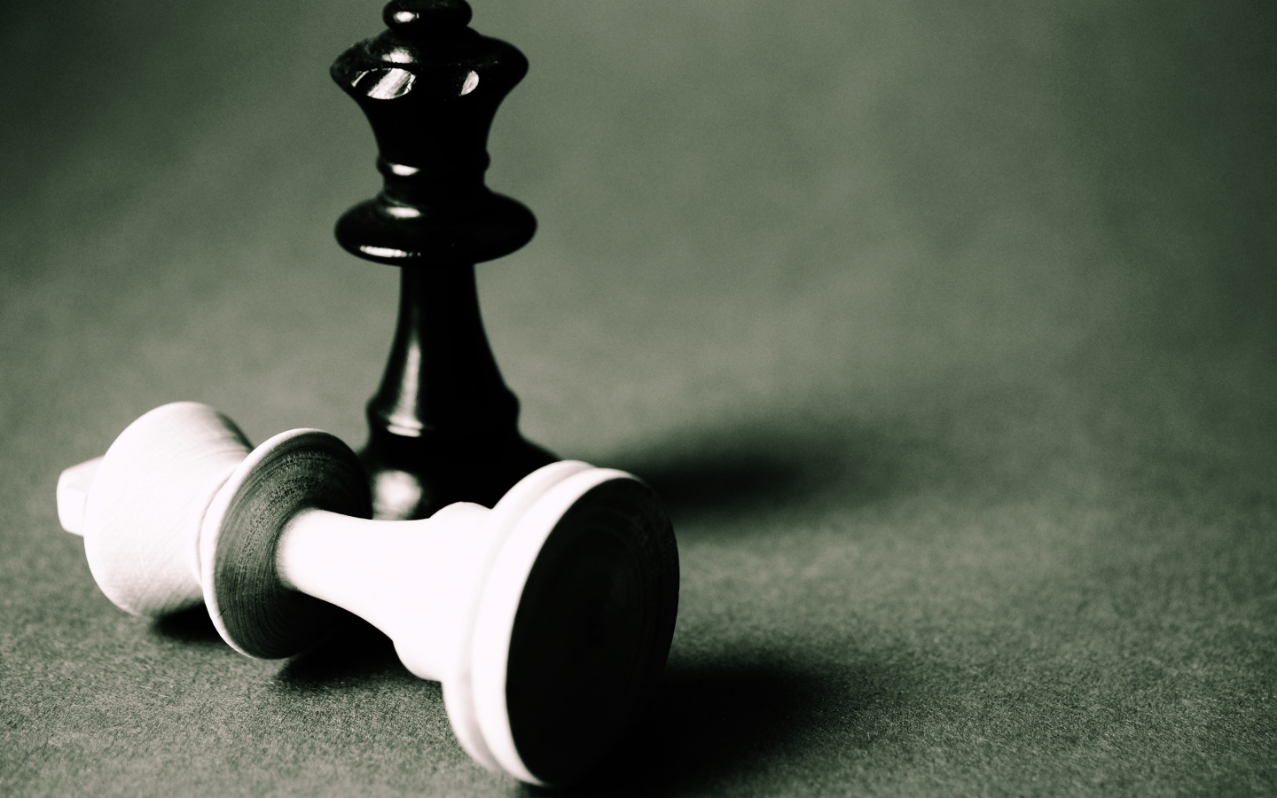 Черная и белая шахматные фигуры на сером столе