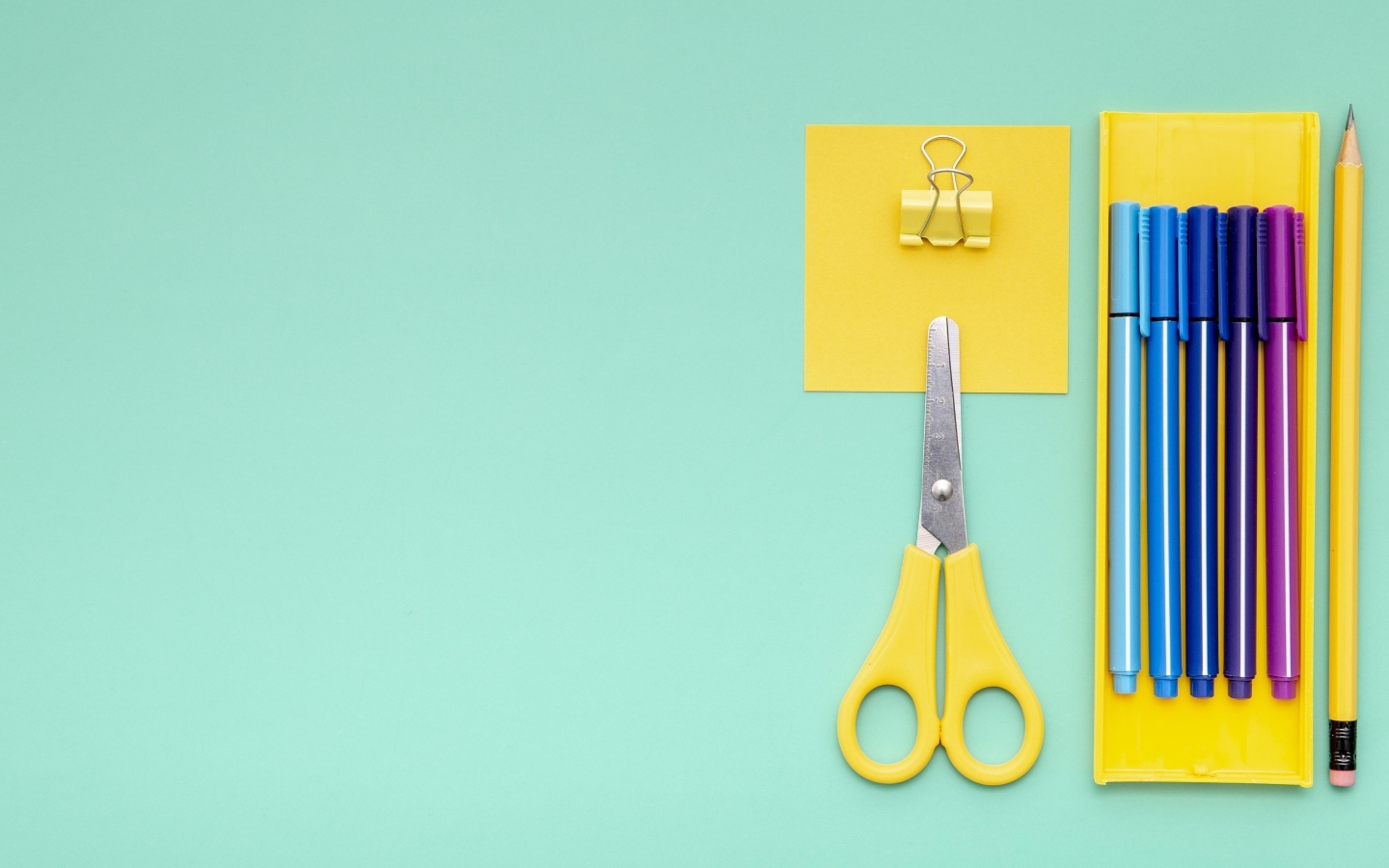 Фломастеры, ножницы и карандаш на голубом фоне