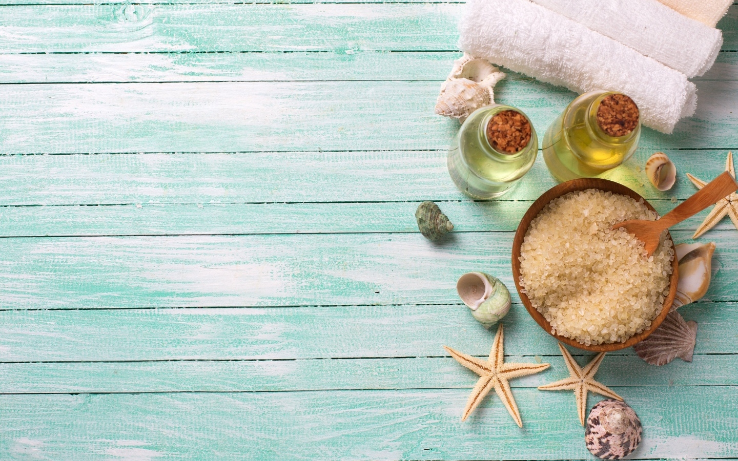 Морская соль, масло и полотенца на голубом столе
