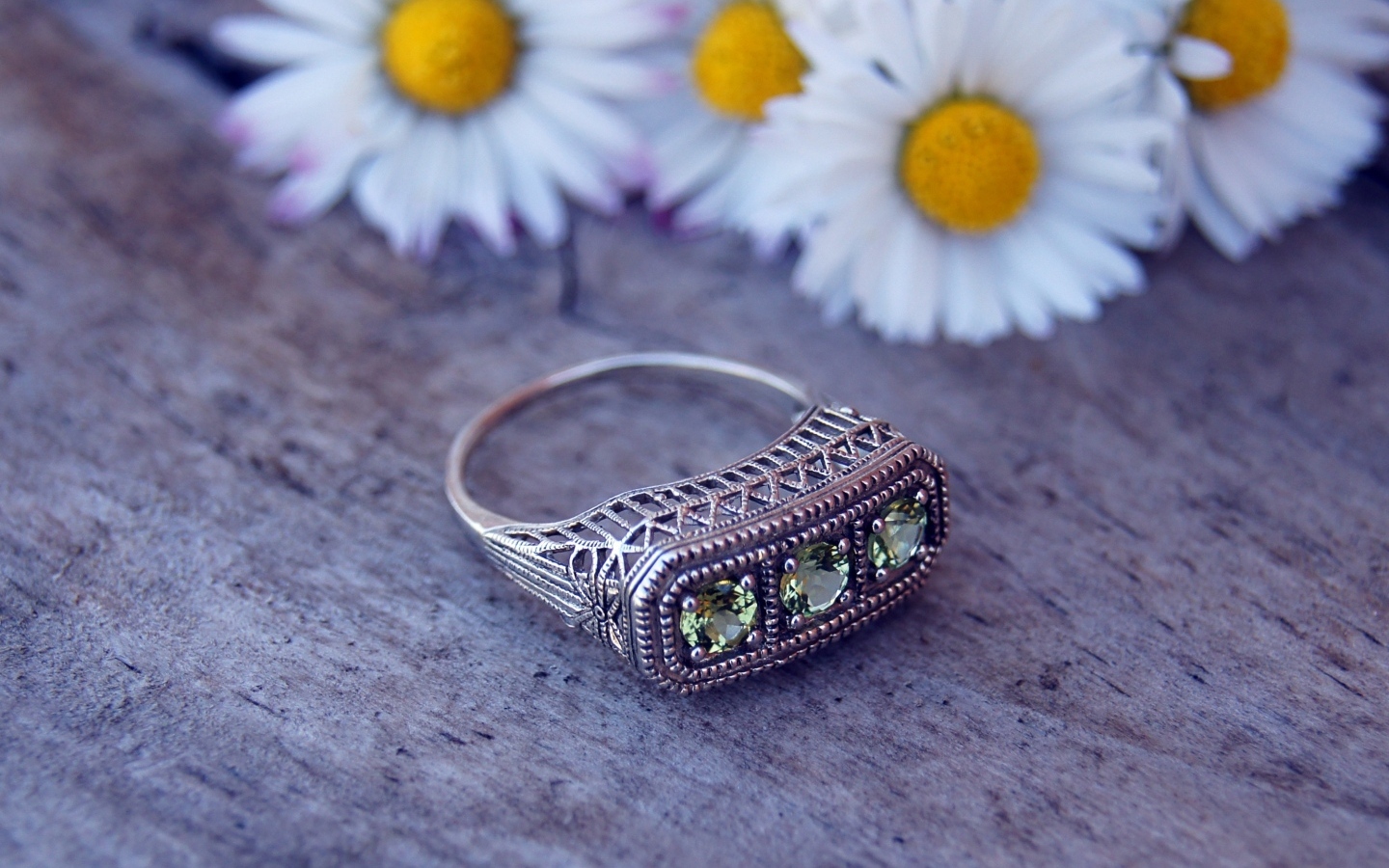 Старинный перстень на столе с ромашками