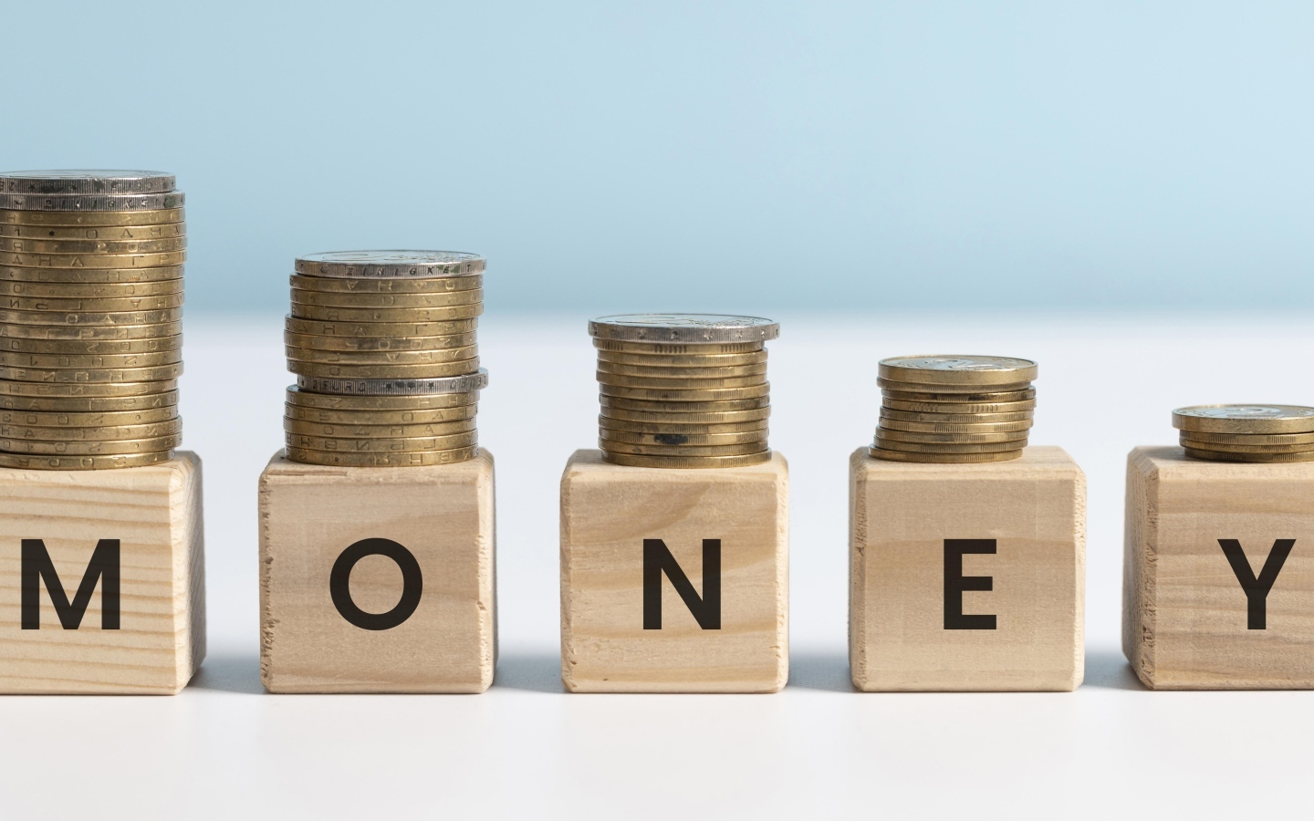 Кубики с золотыми монетами на голубом фоне