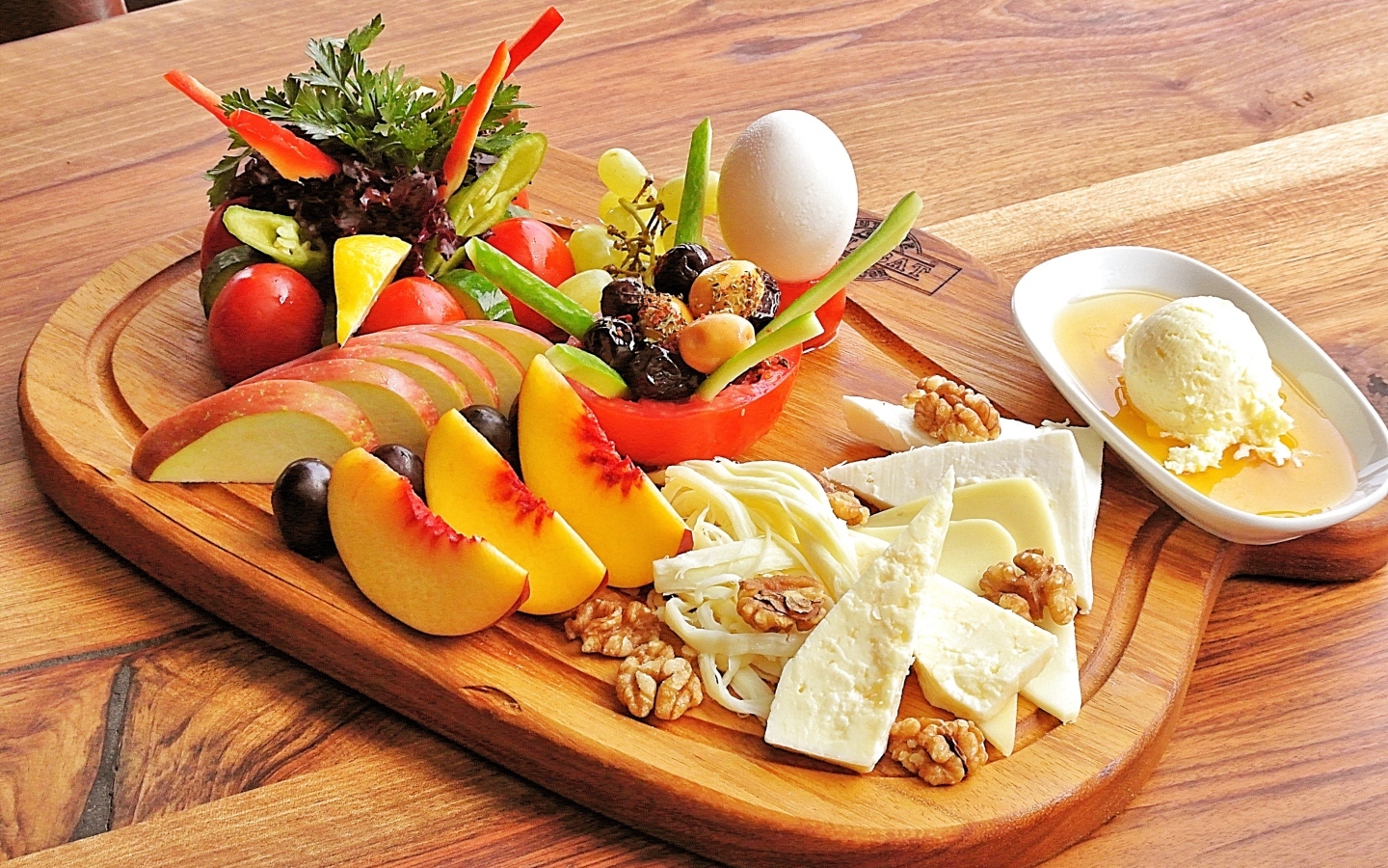 Сыр на доске с фруктами и салатом