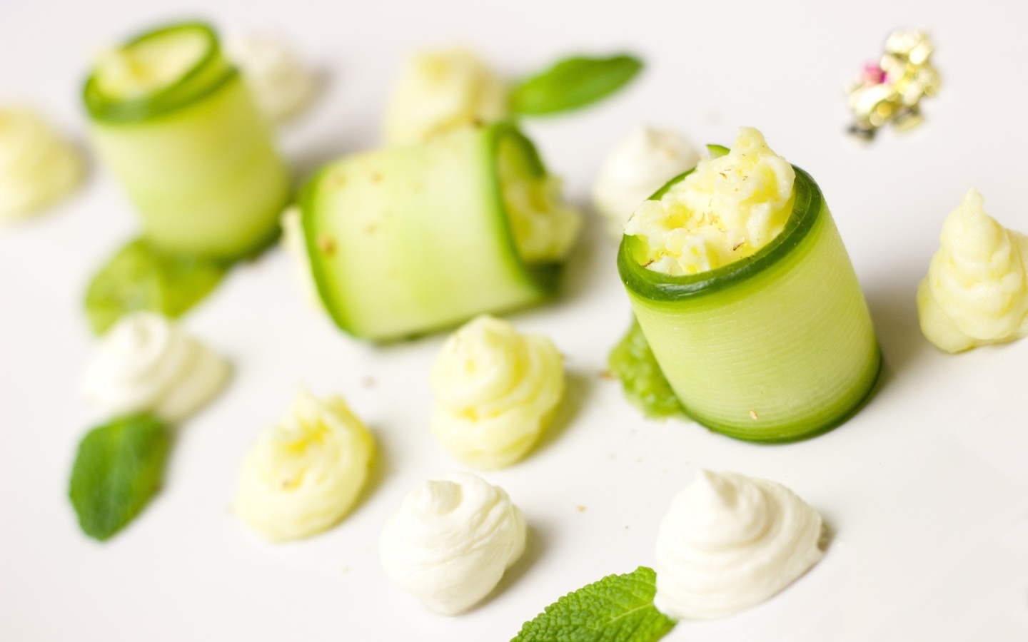 Рулетики из огурца с кремом на белом фоне