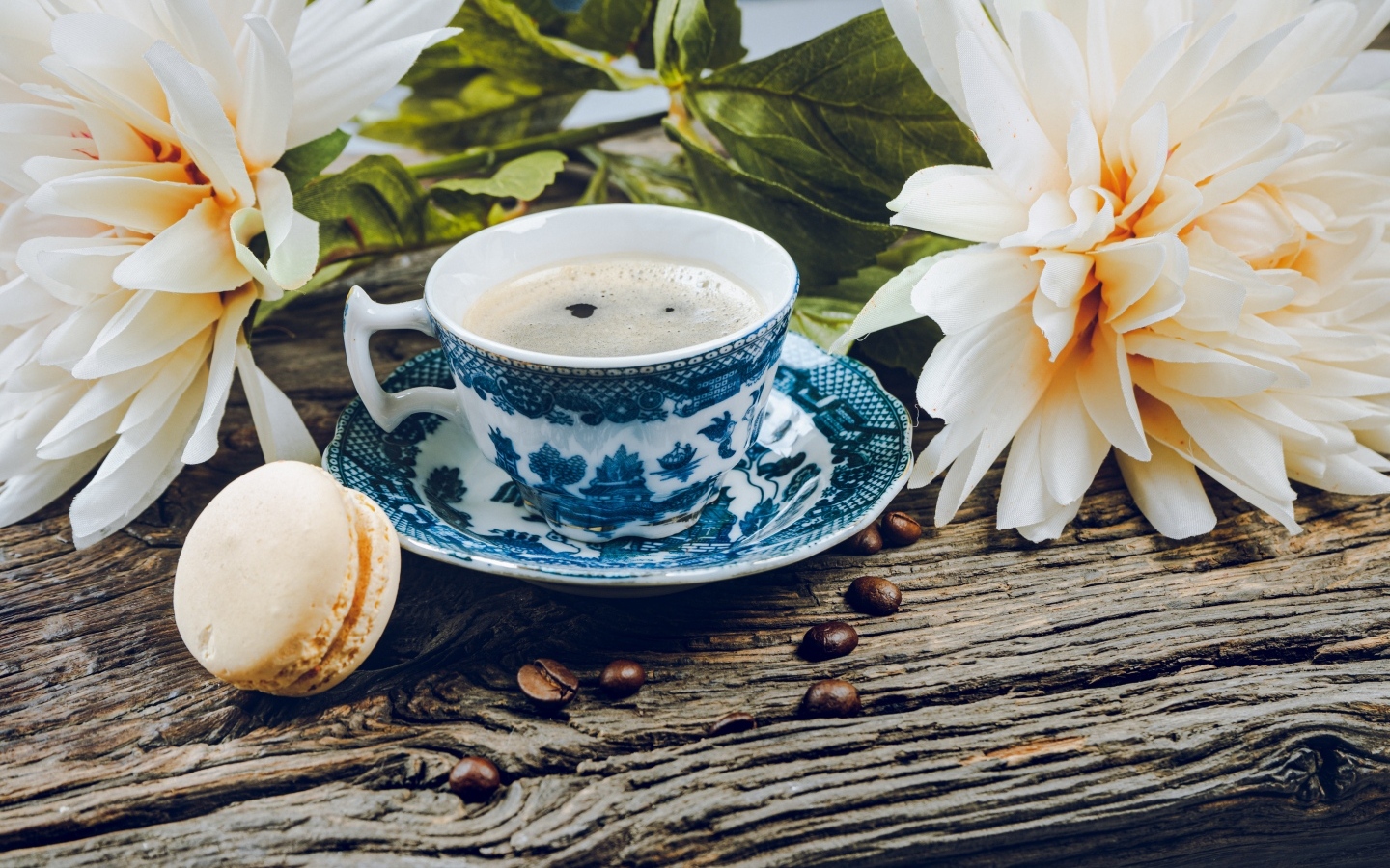 Чашка кофе с макарунами на столе с цветами