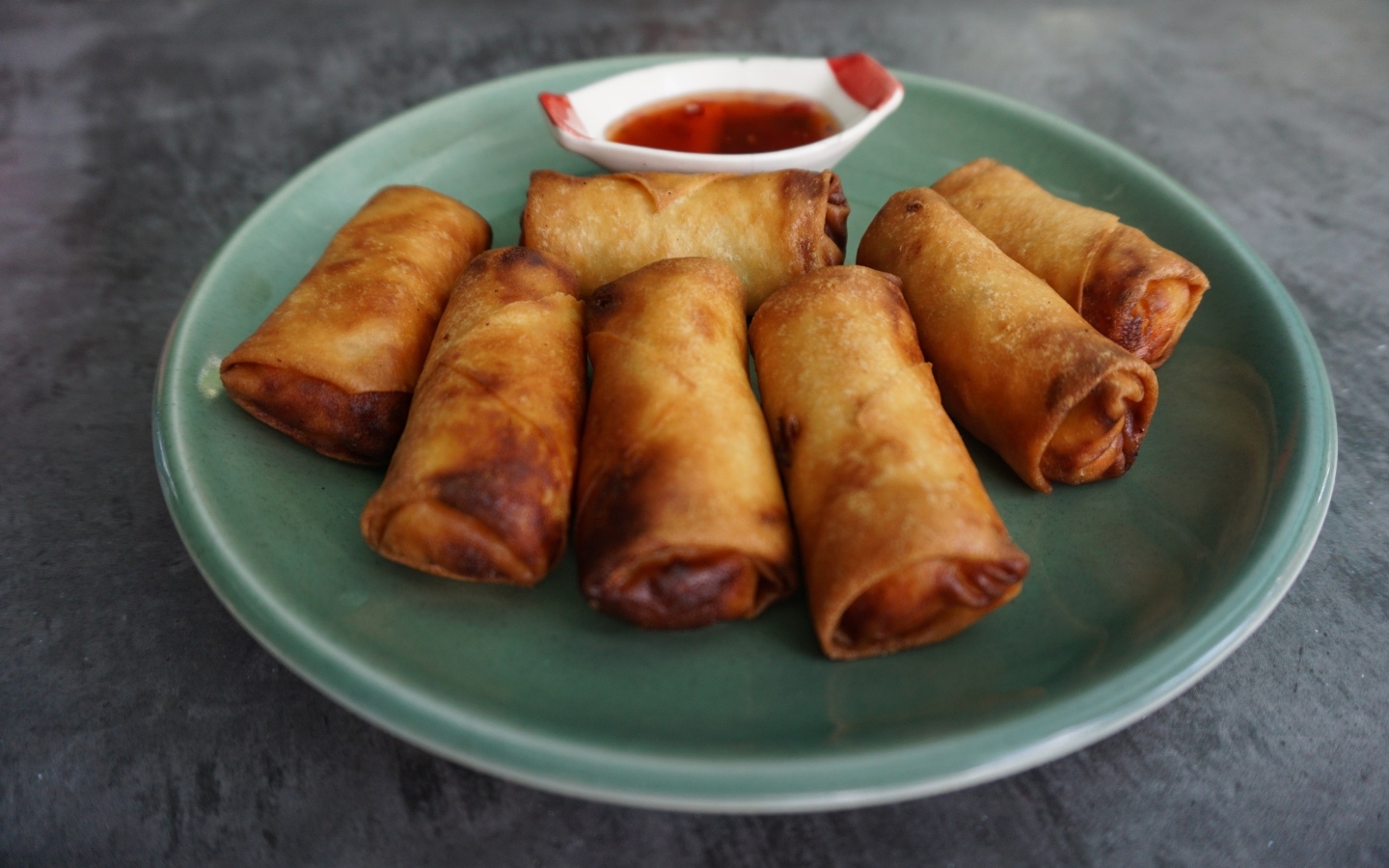 Яичные рулетики на большой тарелке с соусом