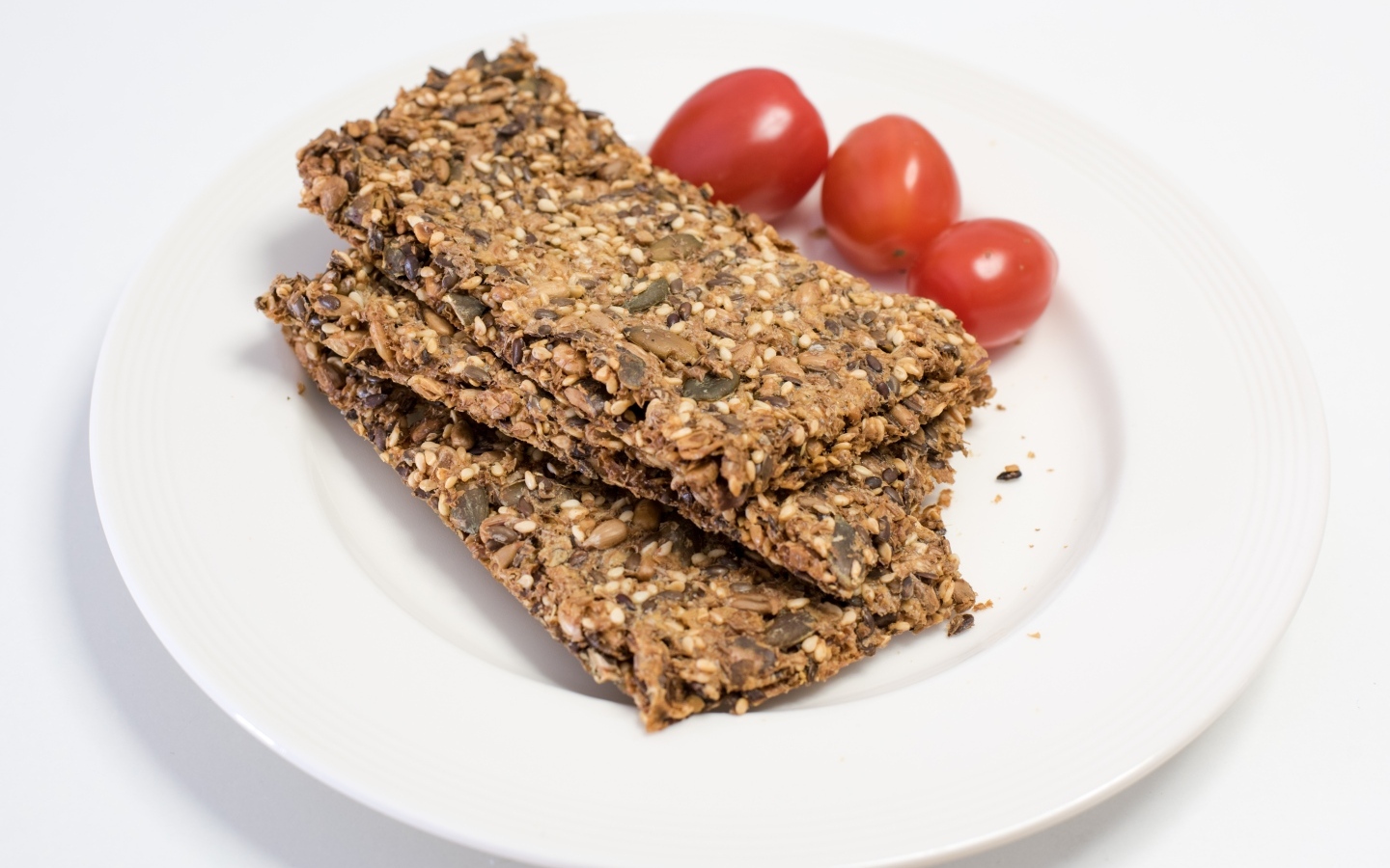 Полезны злаковые хлебцы на тарелке с помидорами