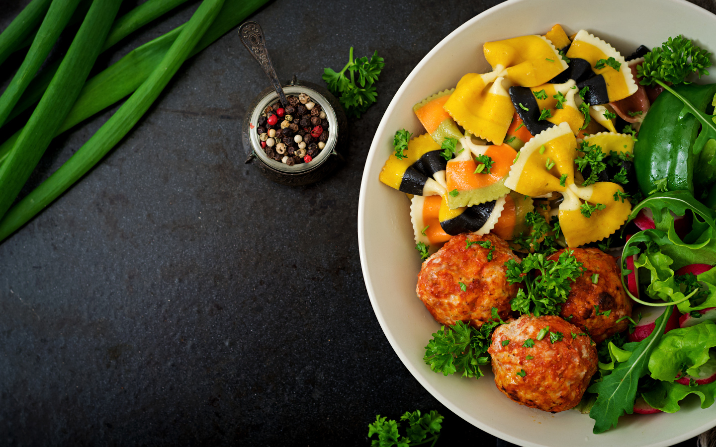 Паста с тефтелями и салатом в тарелке