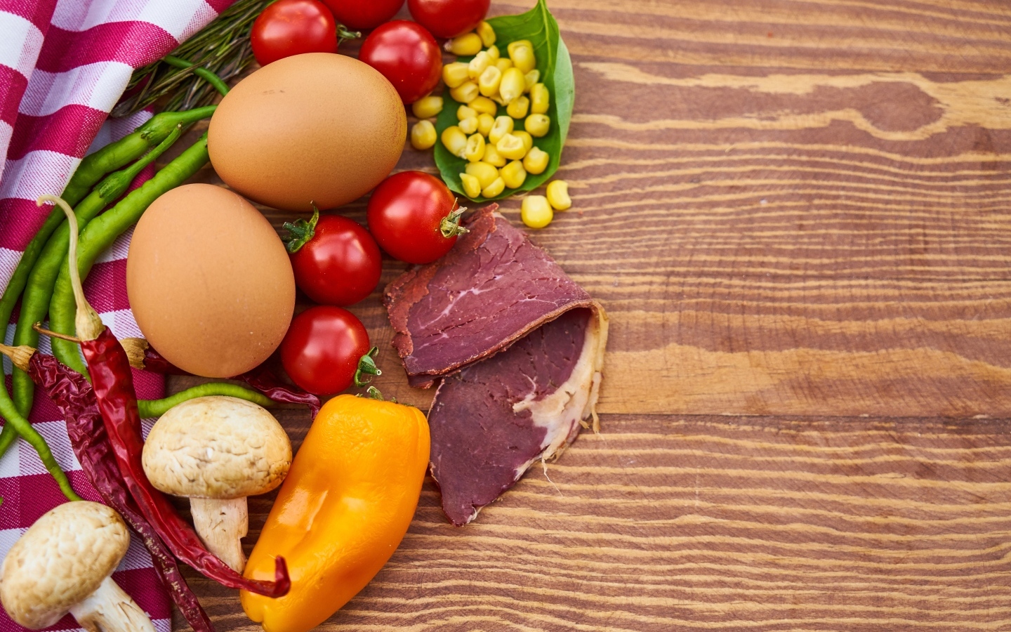 Продукты на деревянном столе с полотенцем