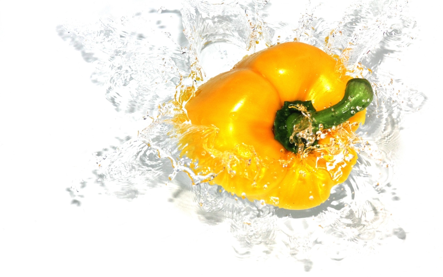 Желтый сладкий перец в воде на белом фоне