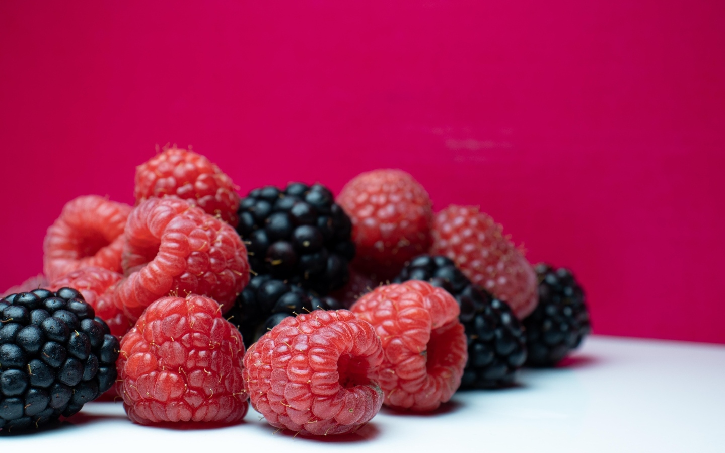 Ягоды черники и малины на красном фоне