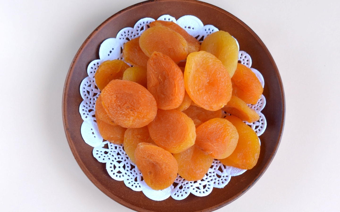 Курага с тарелке на сером фоне