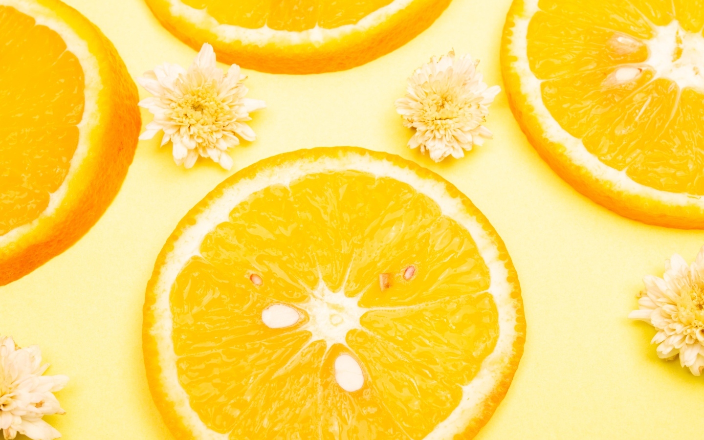 Апельсин с цветами хризантемы на желтом фоне