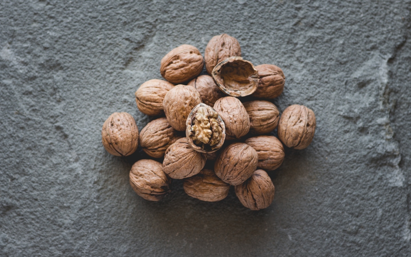 Куча грецких орехов на сером столе