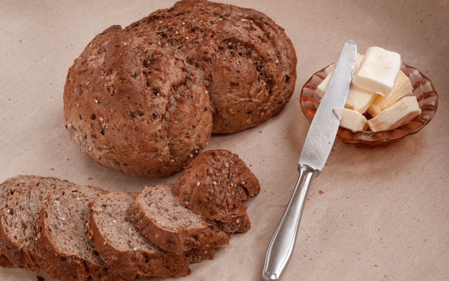 Ржаной хлеб со сливочным маслом и ножом на столе