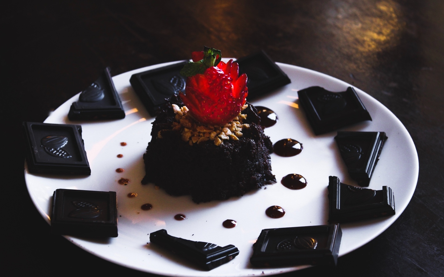 Десерт брауни на большой белой тарелке с шоколадом