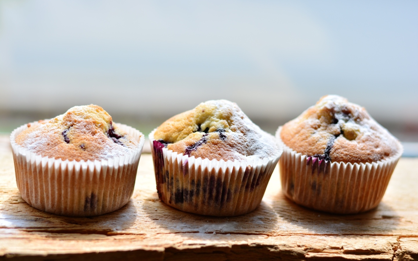 Три вкусных сладких кекса с сахарной пудрой на столе