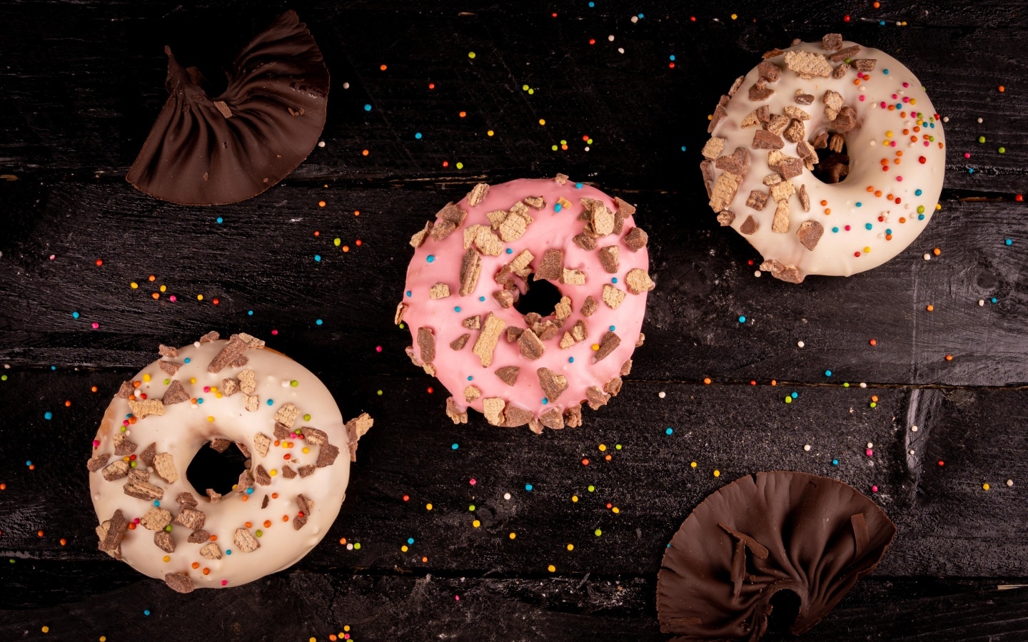 Три сладких пончика на черном столе