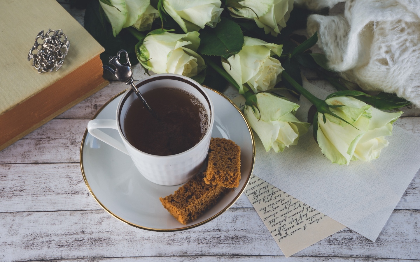 Чашка кофе на столе с букетом белых роз