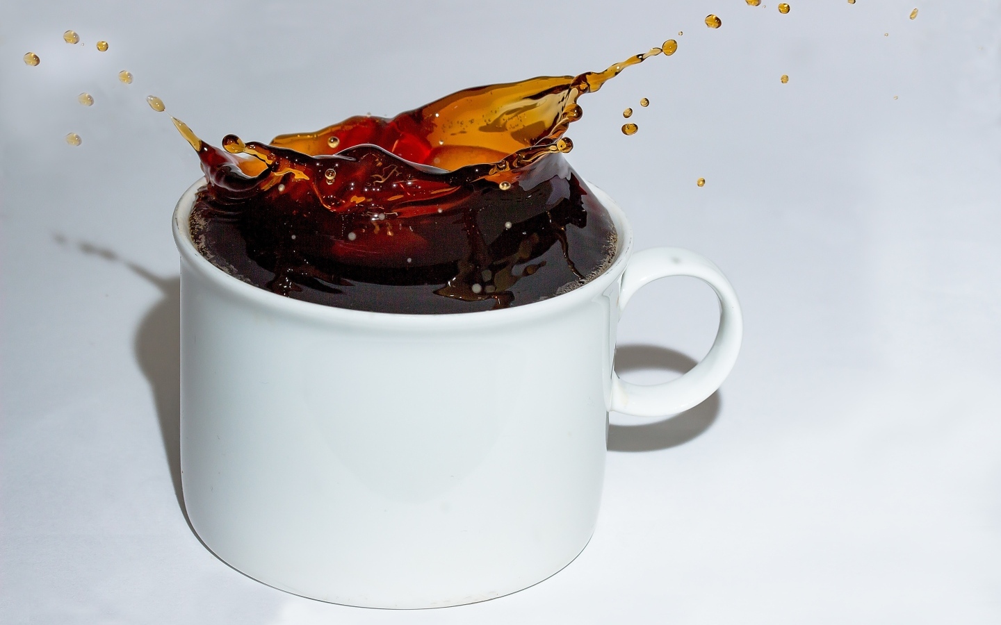 Чашка кофе с брызгами на сером столе