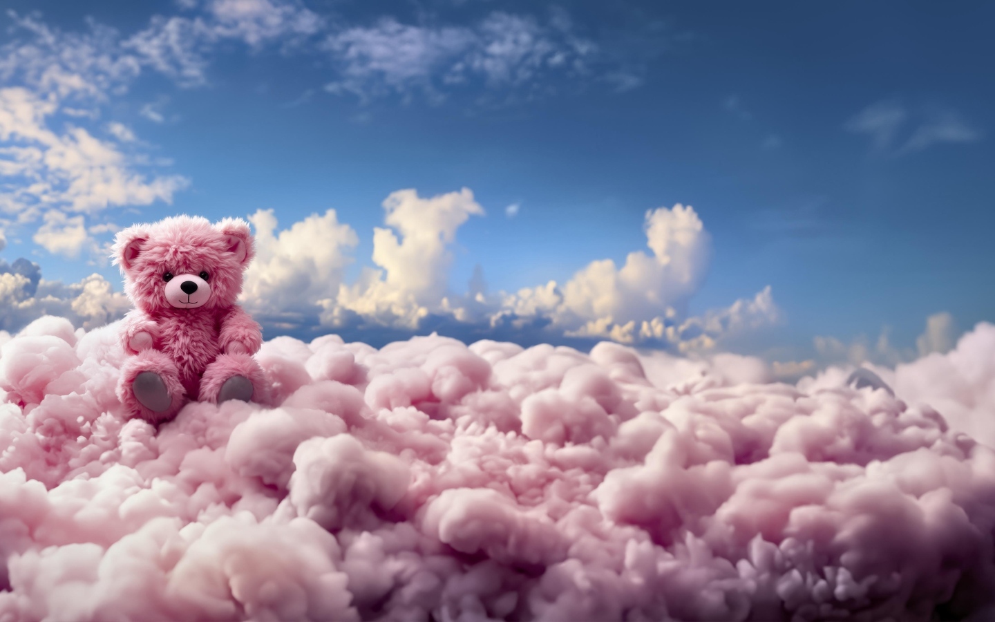 Розовый плюшевый медведь сидит на облаке