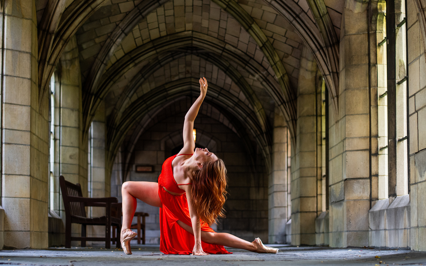 Девушка в красном наряде танцует в здании