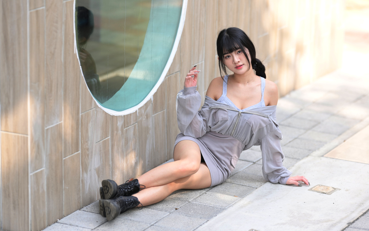 Азиатка лежит на полу у окна