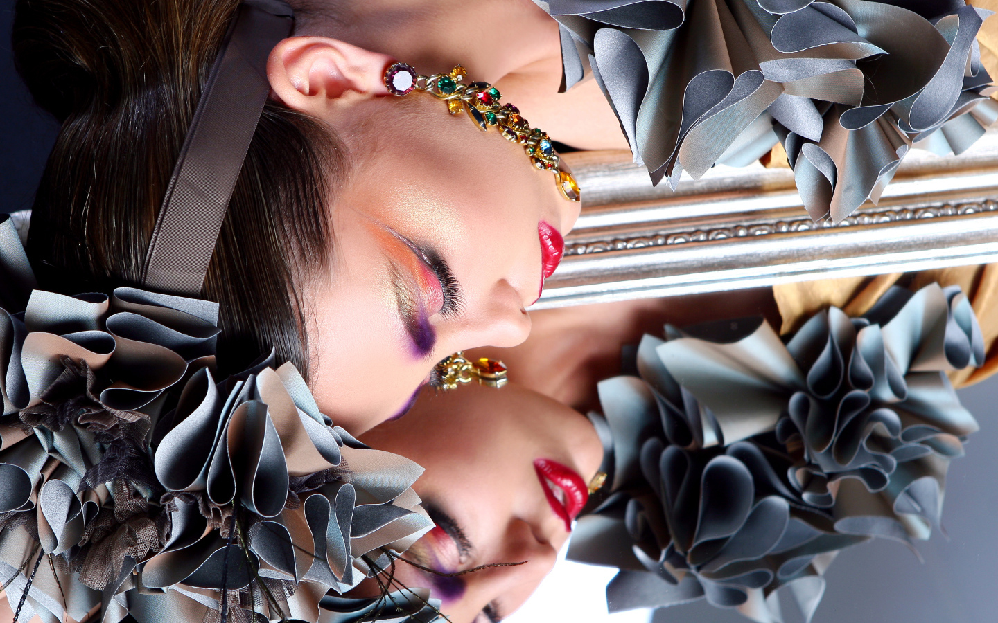 Красивая девушка с ярким макияжем отражается в зеркале