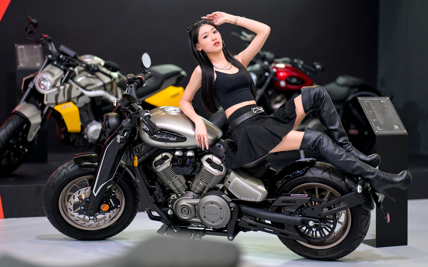 Брюнетка азиатка лежит на мотоцикле