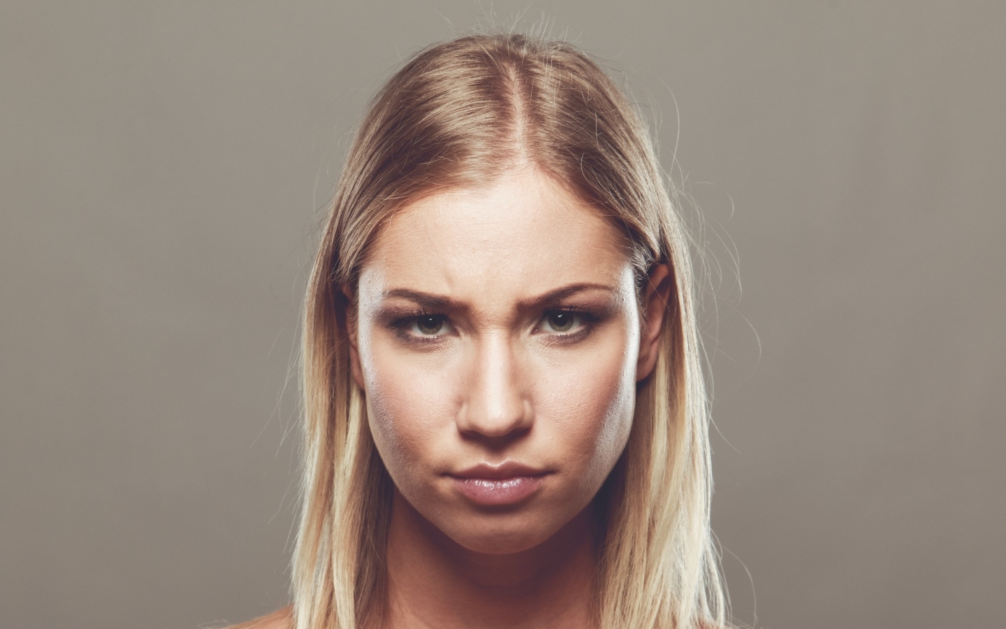 Серьезная девушка с короткой стрижкой на сером фоне