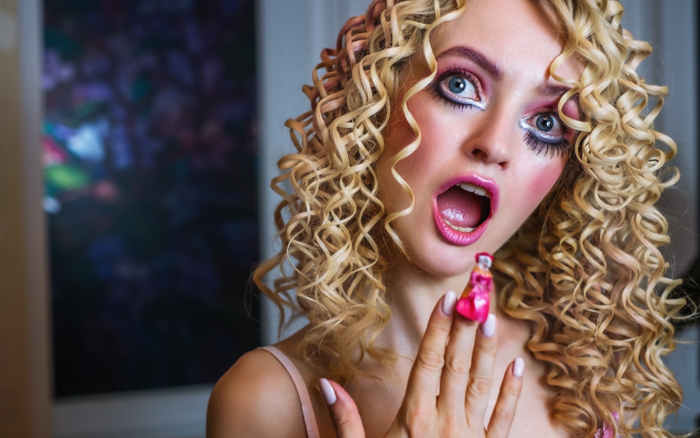 Удивленная девушка блондинка с макияжем куклы