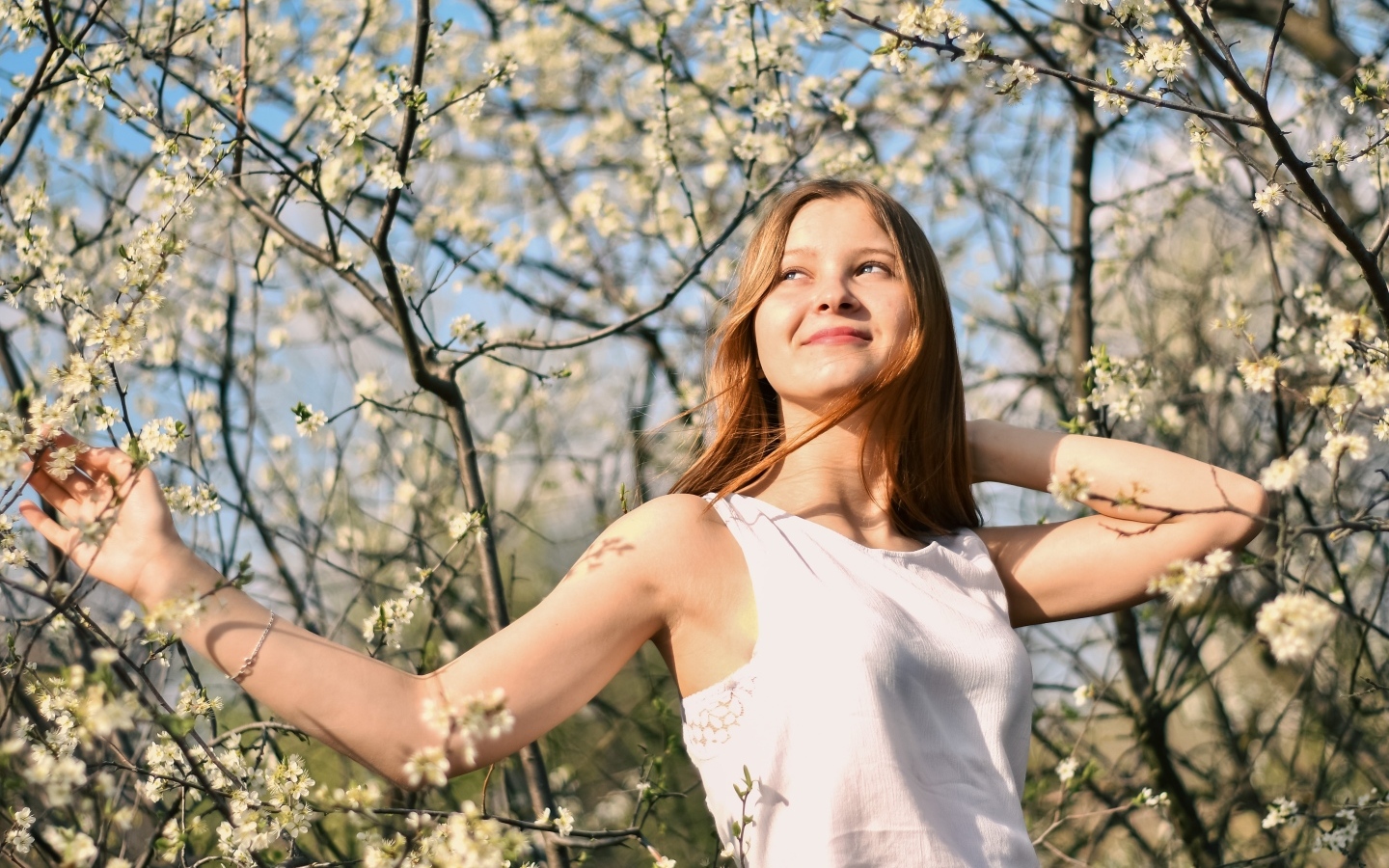 Молодая девушка у цветущего дерева весной
