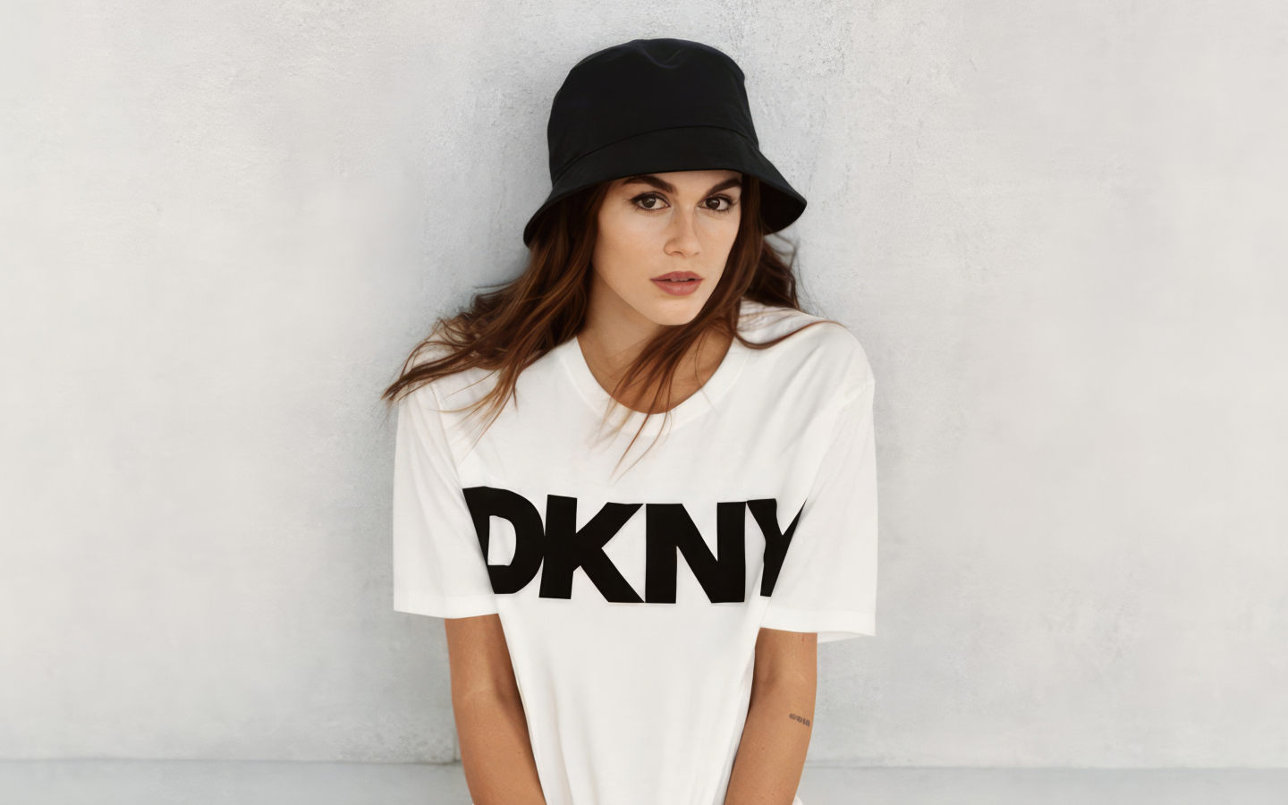 Американская модель Кайя Гербер в черной панаме у стены