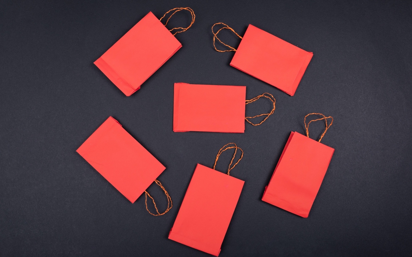 Красные пакетики для подарков на черном столе
