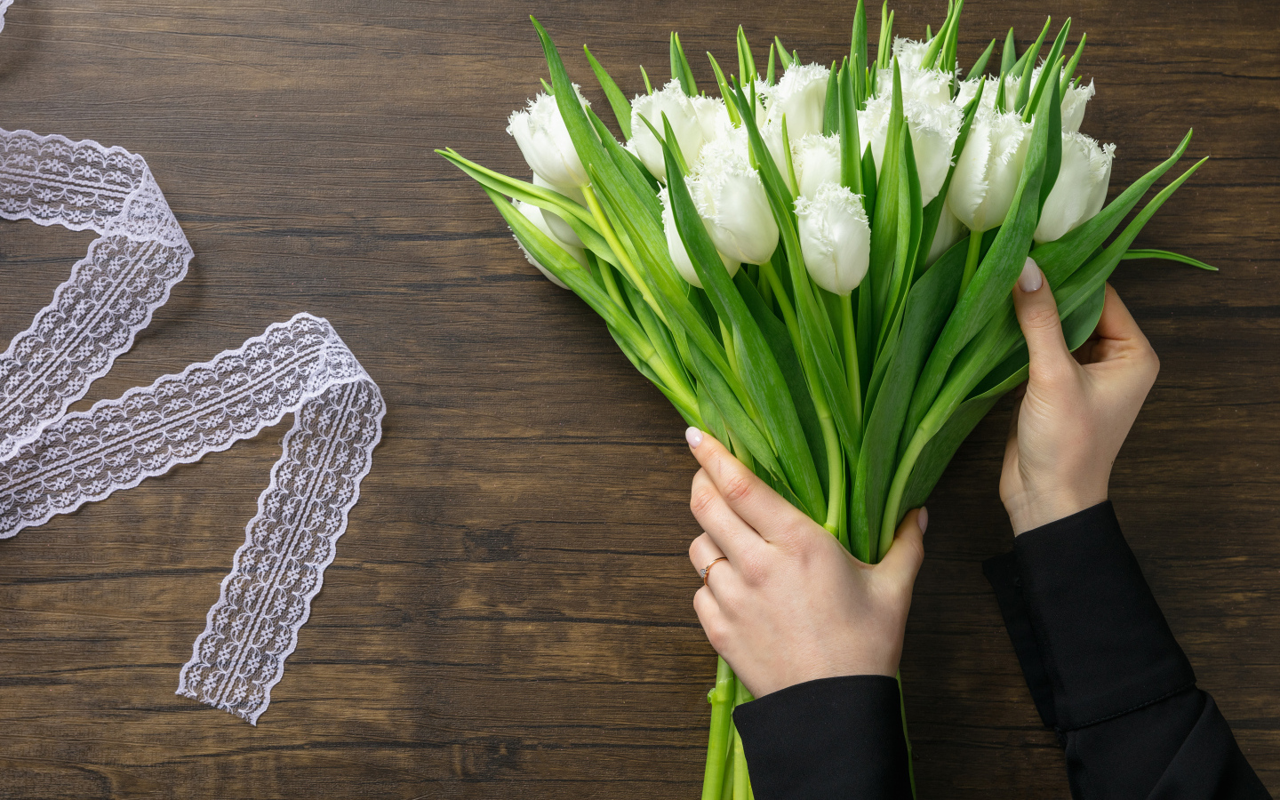 Большой букет белых тюльпанов с лентой на столе на 8 марта