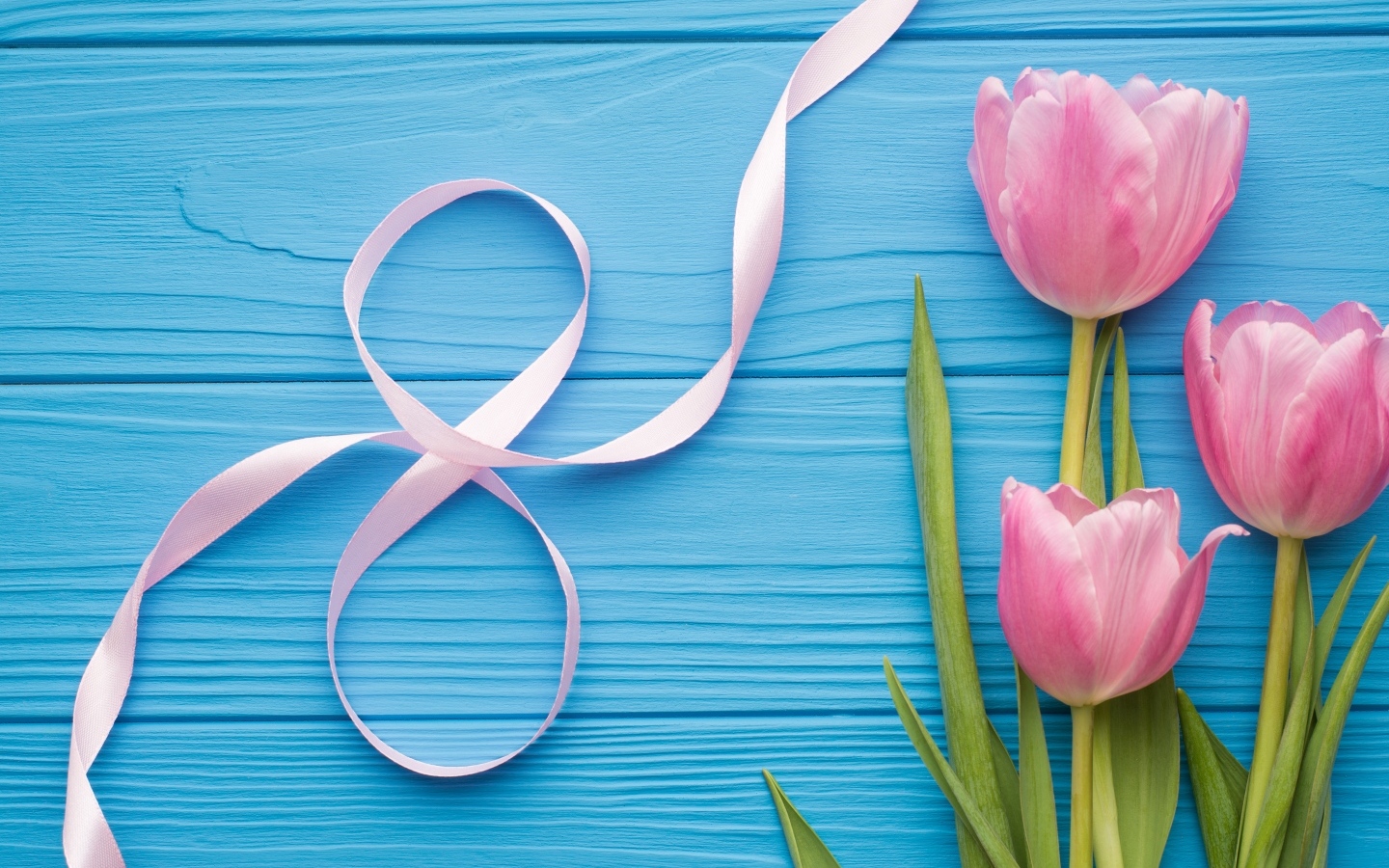 Цифра восемь из ленты с розовыми тюльпанами на голубом столе на Международный женский день