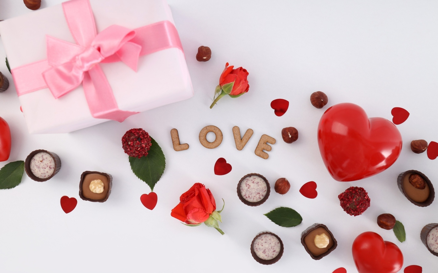 Подарок и сердечки с конфетами на столе на День Святого Валентина