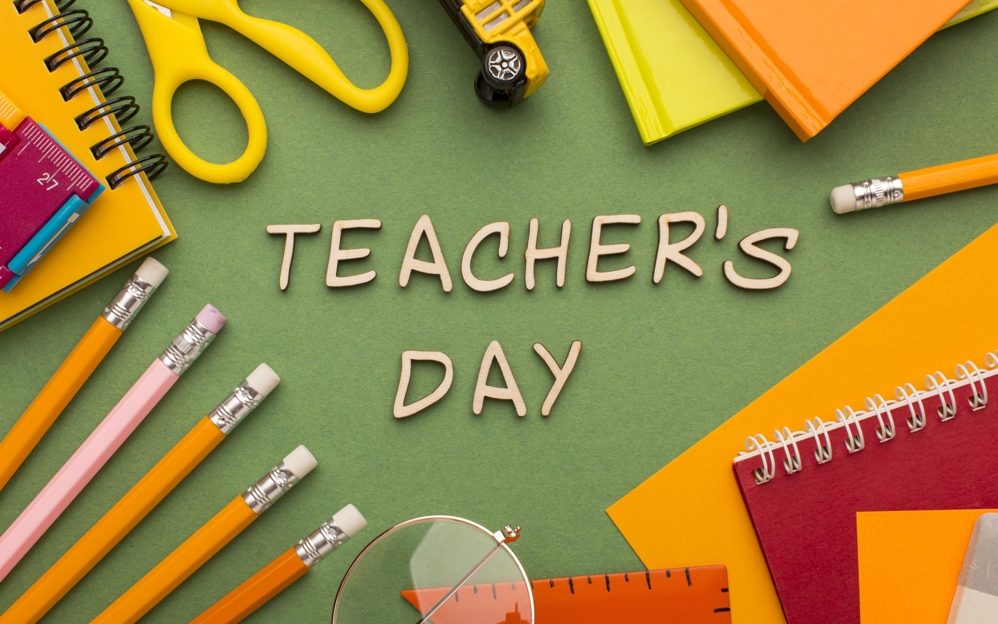 Канцелярские предметы на зеленом столе на день учителя