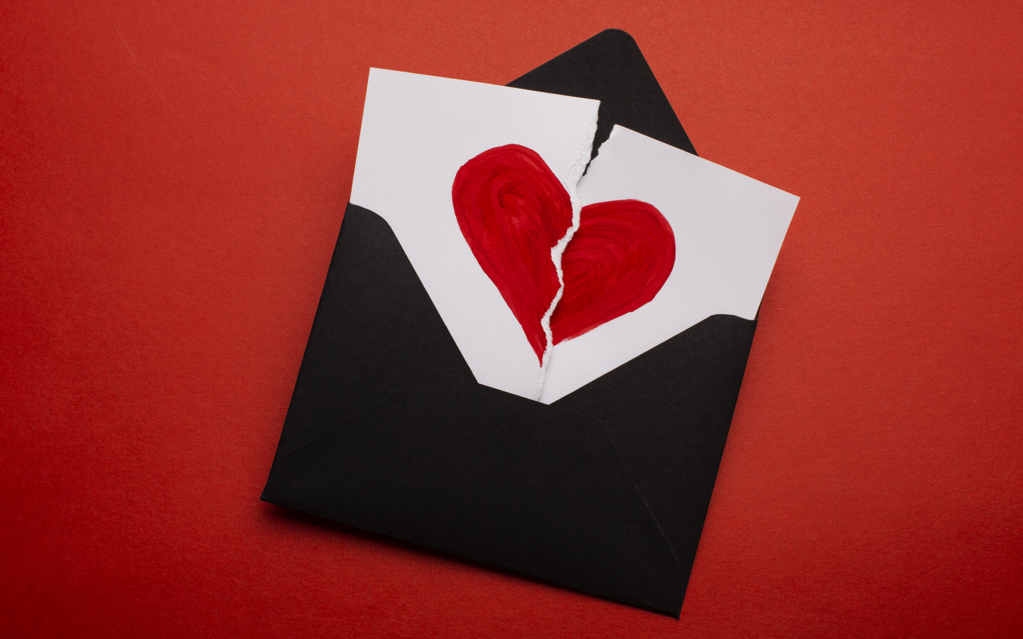 Черный конверт с нарисованным разбитым сердцем