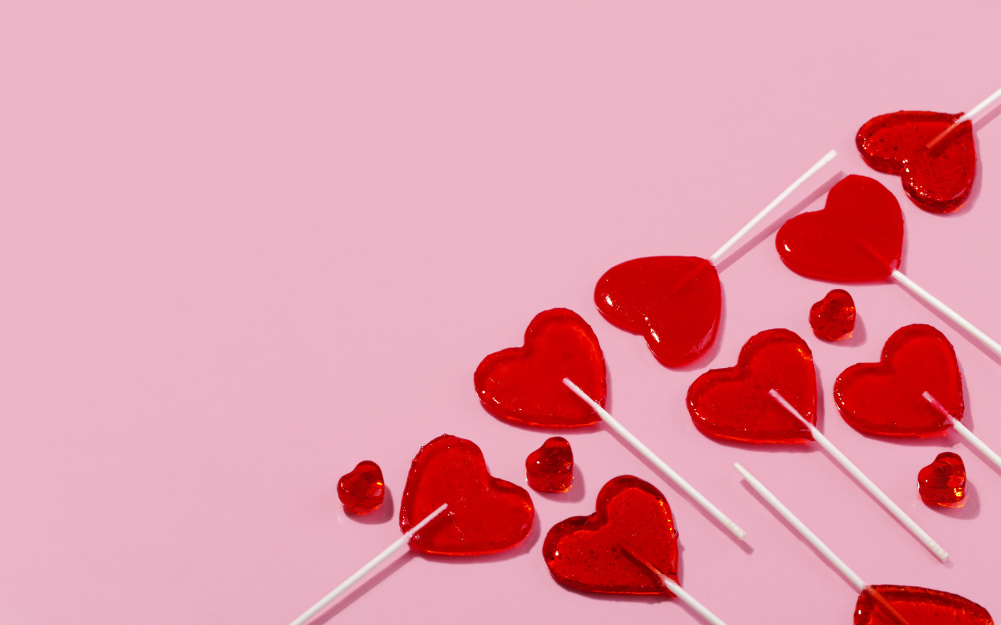 Леденцы в форме сердца на розовом фоне
