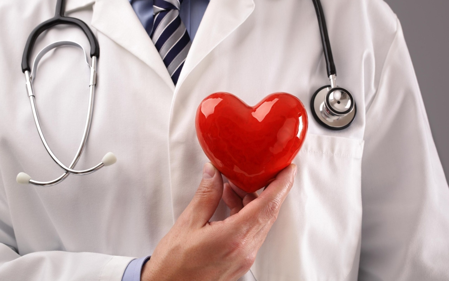 Красное сердце в руках доктора в белом халате