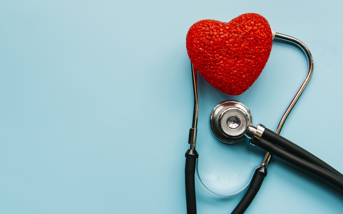 Красное сердце с стетоскопом на голубом фоне