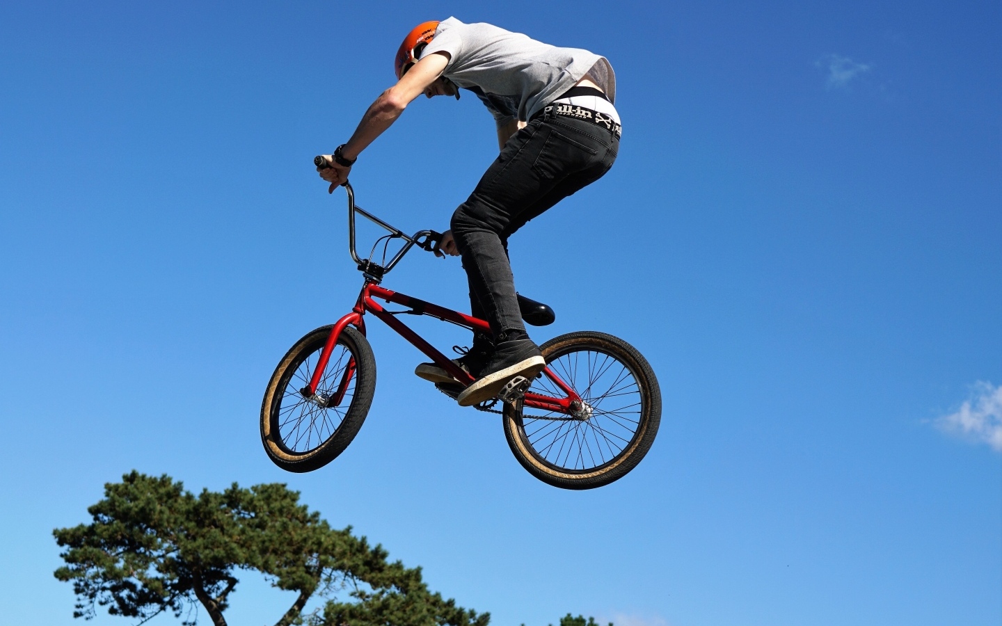 Мужчина делает прыжок на велосипеде на фоне неба