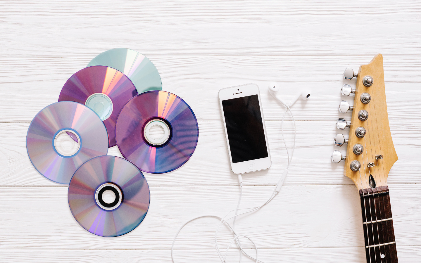 Диски с телефоном и гитарой на белом фоне