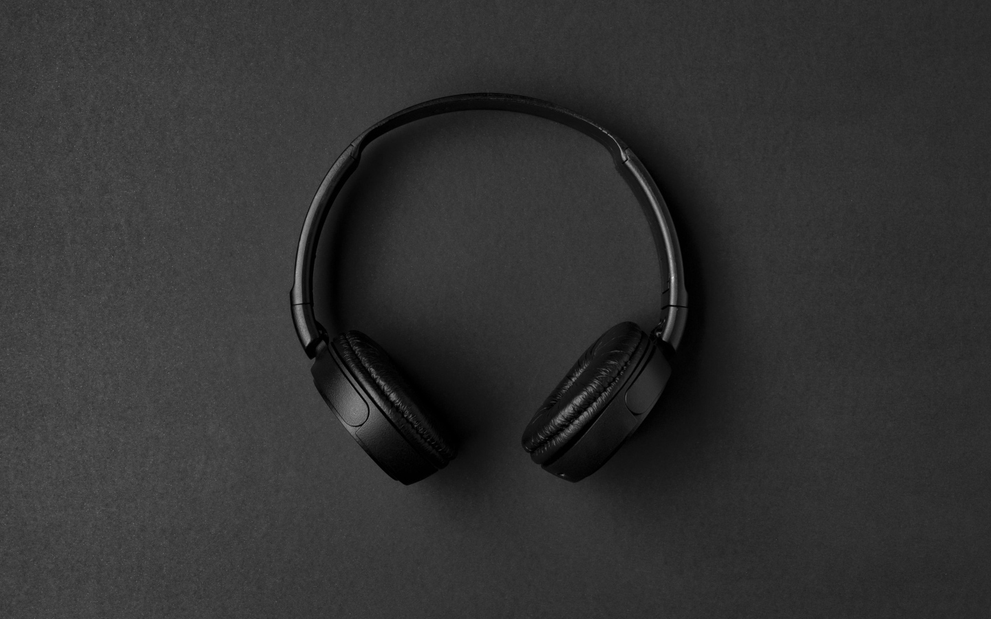 Большие черные наушники на сером столе