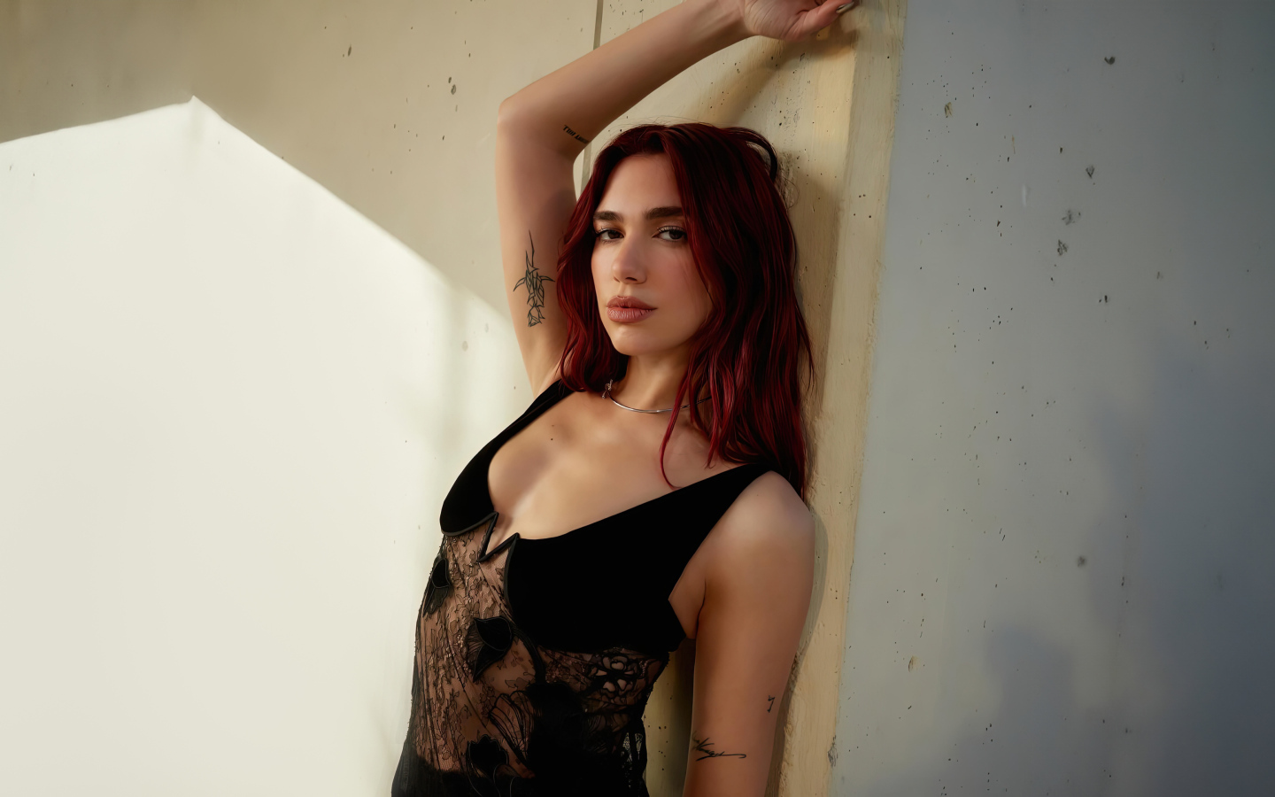 Певица Дуа Липа стоит у стены