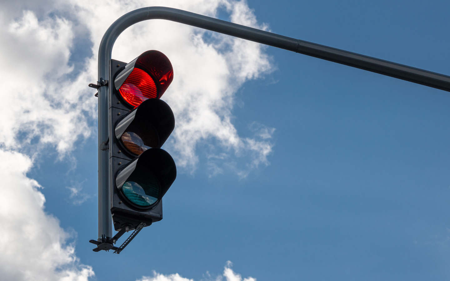 Красный свет светофора на фоне неба