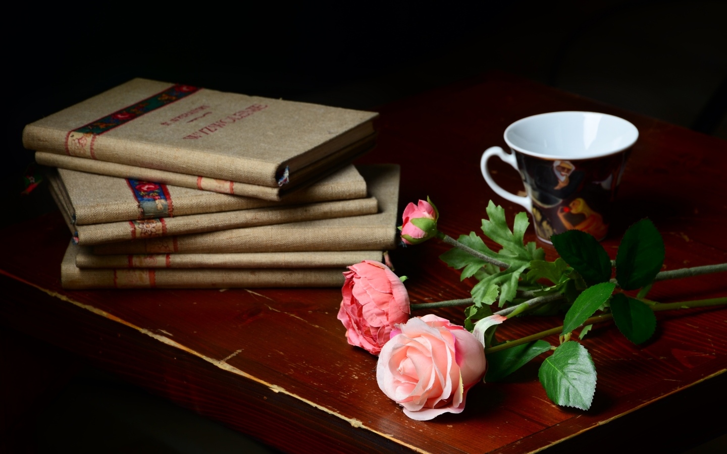 Книги на столе с цветами и чашкой