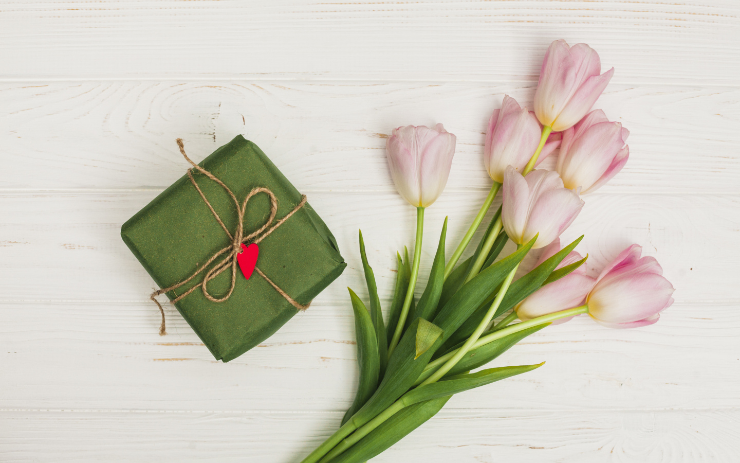 Букет розовых тюльпанов на столе с подарком